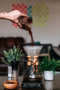 pouring grounds into pour over coffee filter 